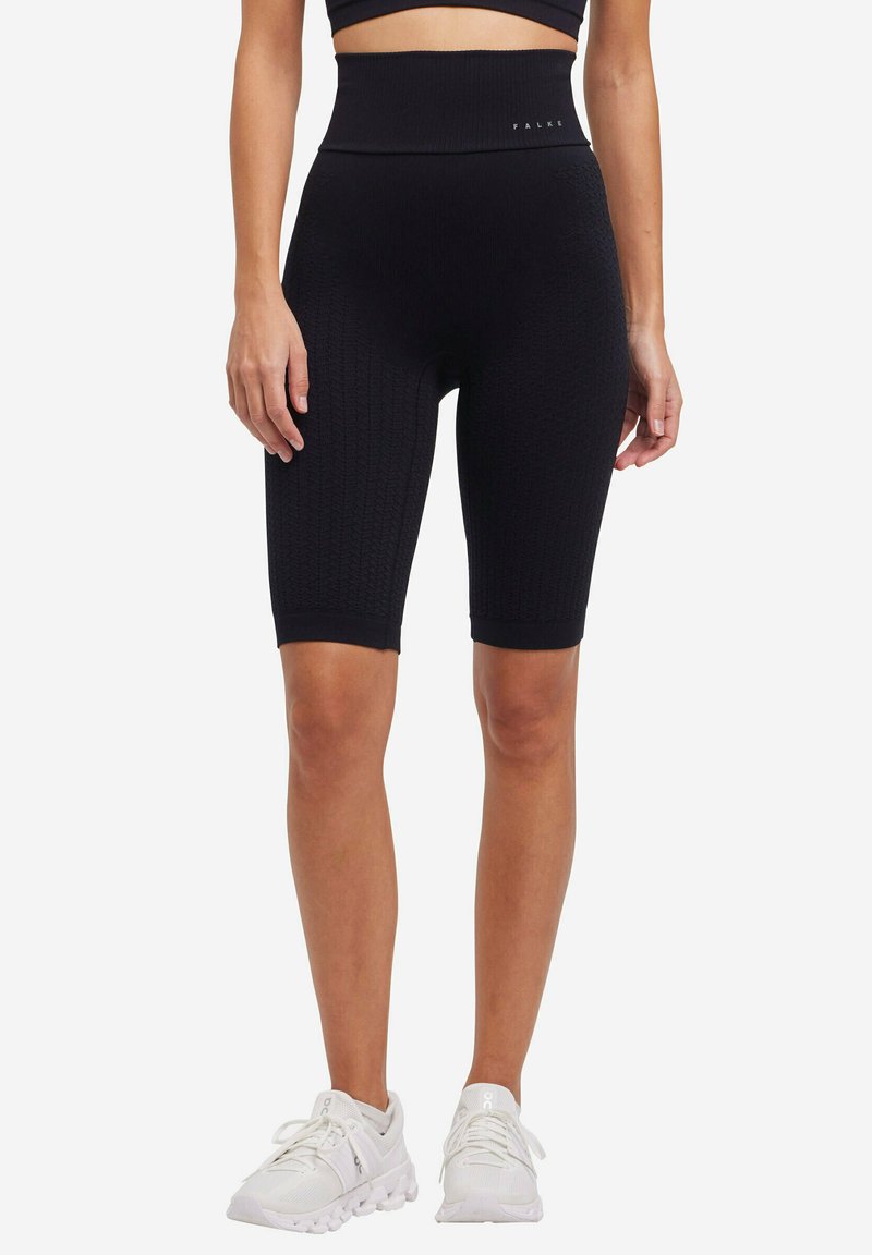 Zwarte gebreide fietsbroek met een hoge tailleband, gekenmerkt door een textuurpatroon en een aansluitend ontwerp. De merknaam "FALKE" is zichtbaar op de tailleband.