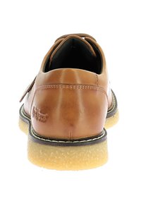 Chaussure en cuir marron avec une forme arrondie, des détails cousus et une semelle en caoutchouc beige avec un contour noir contrastant. La vue arrière montre le logo de la marque.