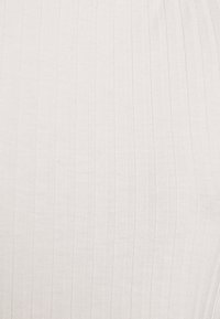 Primo piano di un tessuto bianco a coste con texture a maglia verticale.