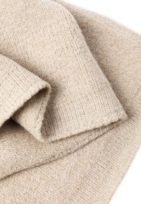 Beige sweater lavet af blødt, tekstureret strikstof, med løs pasform og synlig syning, samt en diskret glans fra metaltråde.