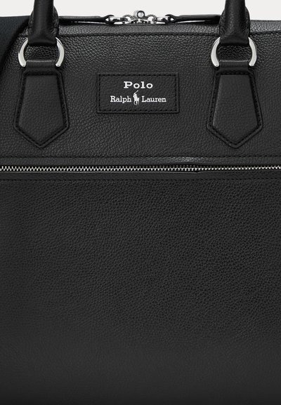 Black leather handbag featuring a textured finish, silver hardware, top handles, and a zippered compartment. Includes a logo plaque.