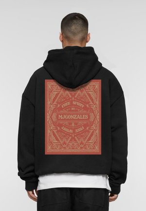 Zwarte hoodie met een grote rode grafiek op de achterkant, voorzien van ingewikkelde randontwerpen en tekst die zegt "MJGONZALES" en "FREE SPIRIT 2024."