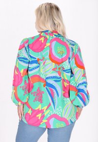 Blusa multicolore in tessuto leggero con un vivace motivo floreale nei toni di rosa, verde e blu. Maniche lunghe con polsini, vestibilità comoda.