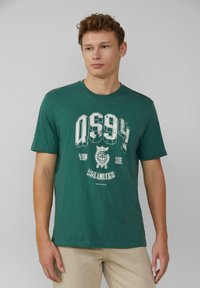 Groene katoenen t-shirt met korte mouwen, voorzien van een grote witte grafische print, inclusief "QS94" en een wereldbolontwerp in het midden.