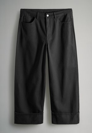 Schwarze Baumwollhose mit geradem Bein, ausgestattet mit zwei vorderen Taschen, einem einzelnen Knopfverschluss und umgeschlagenen Säumen.