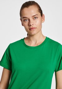 Grön bomull t-shirt med rund halsringning och korta ärmar, som visar en mjuk textur och en klassisk passform.