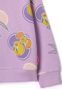 Tessuto di felpa viola con uccelli cartoni animati gialli ripetuti all'interno di forme astratte viola e beige.