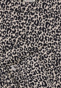 Leggings met luipaardprint, met een beige achtergrond en zwarte vlekken, gemaakt van zachte stof. Inclusief een label op de tailleband.