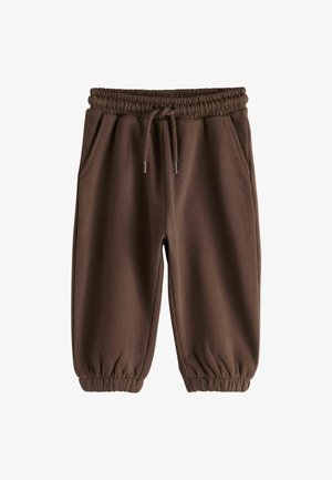 Brune fleecetræningsbukser med elastisk talje, snøre, sidelommer og elastiske manchetter ved anklerne.