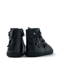 Botas de tobillo de cuero negro con cierre de cremallera, adornadas con apliques florales y acentos de strass. Suela de goma con superficie texturizada.