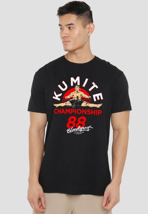 Black t-shirt featuring a colorful graphic of a martial artist in a split, with "KUMITE CHAMPIONSHIP 88" text in bold red and white.