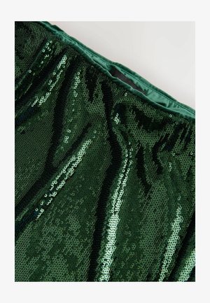 Grüner Paillettestoff mit glatter Textur und einer glänzenden, reflektierenden Oberfläche. Bündchen aus dunklerem grünen Satin gefüttert.