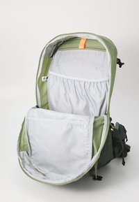 Grüner Rucksack mit grauem Innenfutter, ausgestattet mit einem Reißverschluss oben und einer großen Fronttasche. Enthält verstellbare Träger und einen Schlaufenhandgriff.