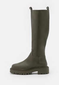 Botas de goma de color verde oliva, altas, con suela gruesa y tacos, y tiradores en la parte superior, diseñadas para usar al aire libre o en clima lluvioso.