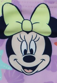 Design del volto di Minnie Mouse in bianco e nero, con un fiocco verde chiaro, su uno sfondo viola pastello con motivi colorati.