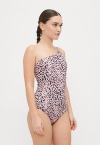 Eno-ramenski kopalni kostim v roza barvi z črnimi leopardjimi vzorci. Gladek material s prilegnjenim dizajnom, z bočnim nabiranjem za elegantnejši videz.
