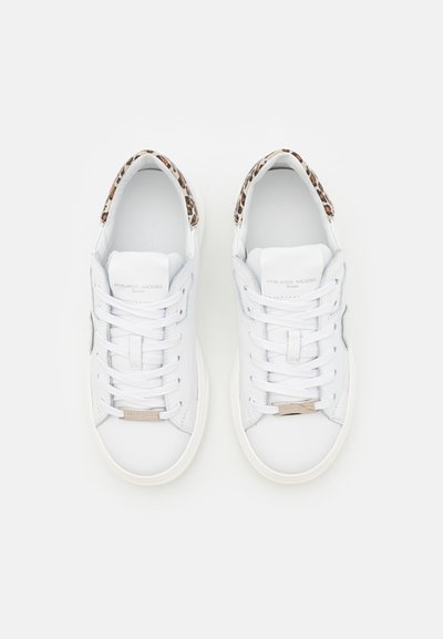 Sneakers bianchi in pelle con lacci, dotati di una fodera in stampa leopardata e di una placca metallica con logo sulla linguetta.