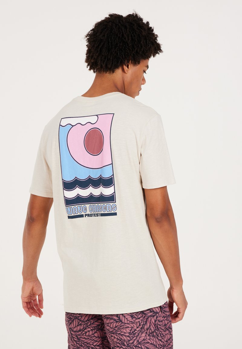 Light beige t-shirt featuring a colorful graphic design on the back with waves, a sun, and the text "WAVE CHASERS PROTEST." Short sleeves.