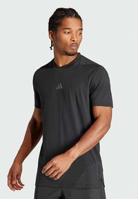 Black short-sleeve athletic shirt made of lightweight fabric, featuring a round neckline and a subtle logo in the center.