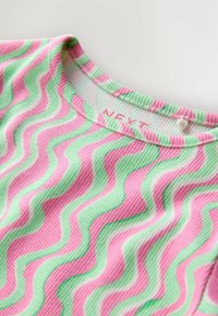 Tricou din material cu dungi, având un model ondulat în nuanțe de roz și verde. Decolteu rotund cu o etichetă inscripționată cu „NEXT” aproape de guler.
