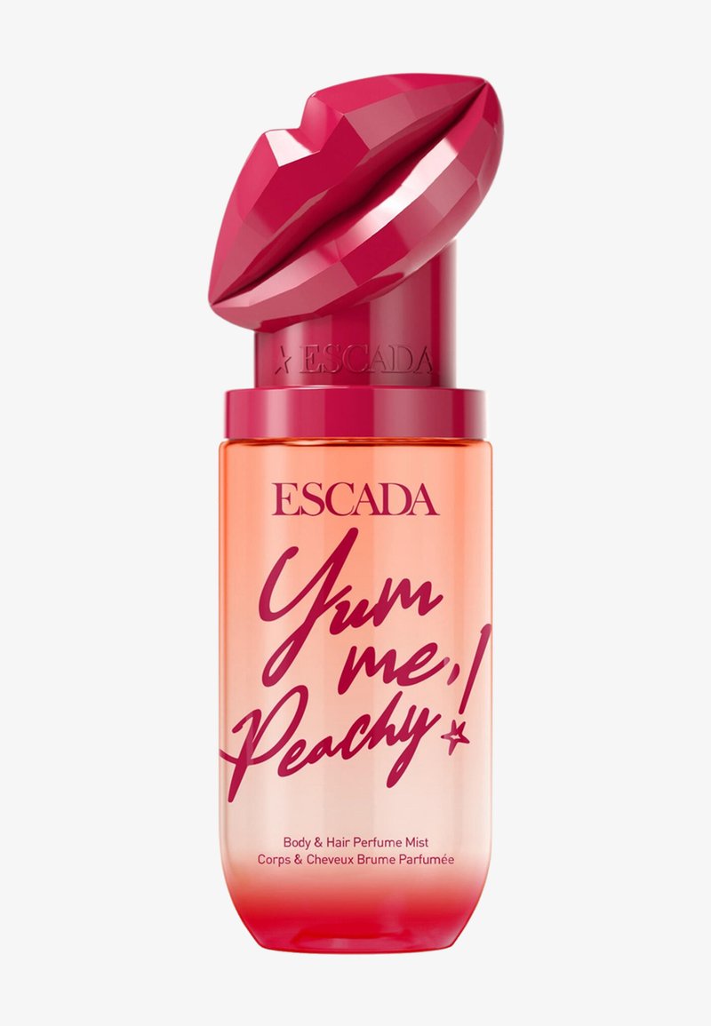 Escada Yum Me Peachy body- en haarparfumfles met rood lipvormig dopje en roze tekst op een fles met perzikkleurige verloop.