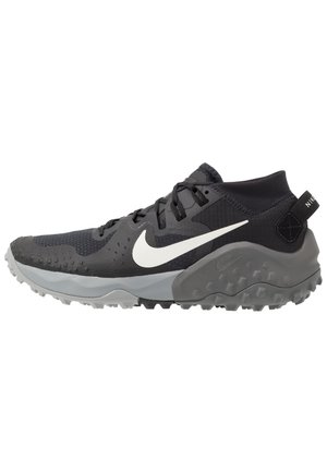 Scarpa sportiva Nike nera e grigia con logo Swoosh bianco, suola testurizzata e collo imbottito alla caviglia, progettata per il trail running o l'uso all'aperto.