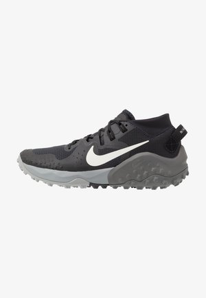 Scarpa sportiva Nike nera e grigia con logo Swoosh bianco, suola testurizzata e collo imbottito alla caviglia, progettata per il trail running o l'uso all'aperto.