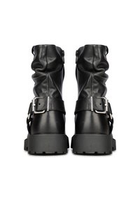 Botines de cuero negro con un diseño arrugado, cierre de cremallera y hebillas en tono plateado, que presentan una suela de plataforma gruesa y texturizada.
