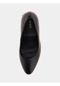 Escarpin en cuir noir avec un bout pointu, texture lisse et logo doré à l'intérieur. Le design est épuré, sans matériel visible ni motifs.