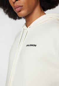 Salomon SAL BOW GRAPHIC HOODIE UNISEX - Pusa - sand
