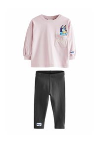 Hellblaues langärmeliges Shirt mit einem Cartoon-Hund auf der Brusttasche, kombiniert mit schwarzen Leggings; beide aus weichem, leichtem Stoff.