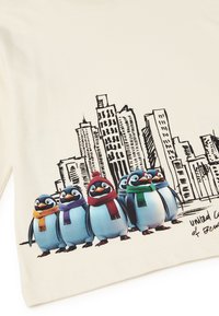 Kremowa koszulka z rysunkowymi pingwinami w kolorowych szalikach na tle czarnej ilustracji miejskiego krajobrazu. Napis: "zjednoczona kolonia bent."