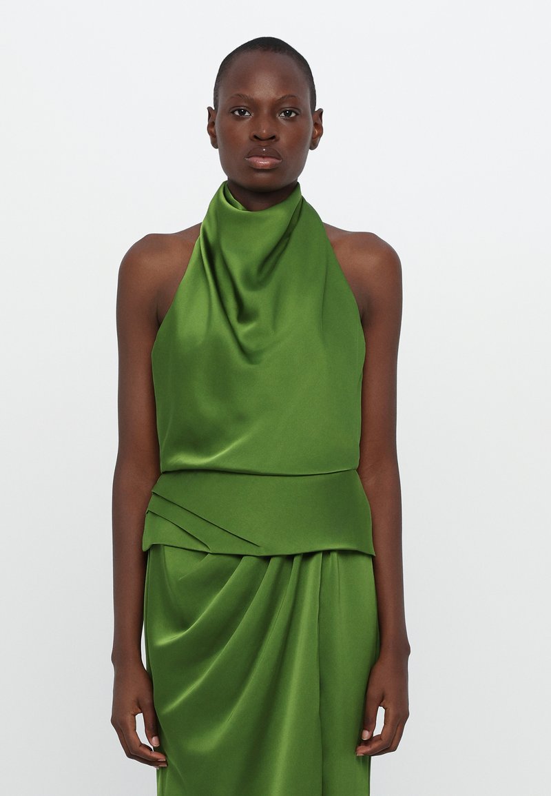 Green satin halter top with draped neckline, fitted bodice, and pleated detailing at the waist. Smooth texture and vibrant color.