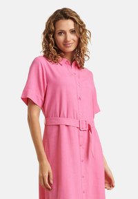 Rosa Leinenhemdkleid mit kurzen Ärmeln, Knopfleiste und tailliertem Gürtel. Glatte Textur und lässiges Design.