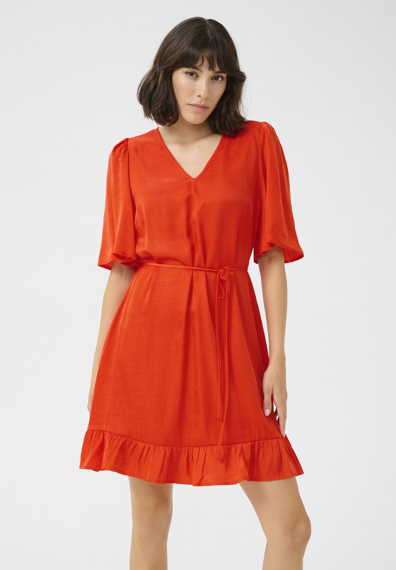 Vestido rojo con escote en V y mangas cortas abullonadas. Presenta una cintura ceñida con un cinturón y un dobladillo con volantes. Está hecho de una tela suave y ligera.