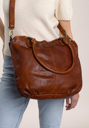 Brown leather hobo bag with a smooth texture, double top handles, adjustable strap, and a rounded bottom. Features brass hardware accents.