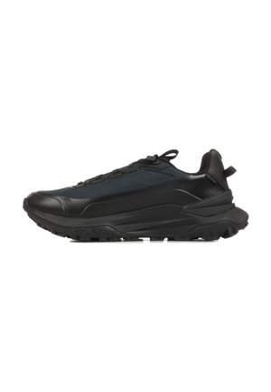 Scarpa da ginnastica nera con suola spessa e strutturata, tomaia in mesh, design con lacci e linguetta sul tallone vista di profilo.