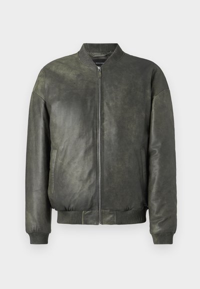 Žalia odinė bomžeriška striukė su užtrauktuku priekyje, briaunuotu apykakliu, rankogaliais ir apačia, turinti šonines kišenes ir lygią, tekstūruotą apdailą.