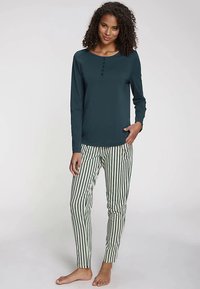 Long-sleeved, dark teal top with button accents paired with fitted, green and white striped pants. Soft fabric, relaxed fit, no visible logo.