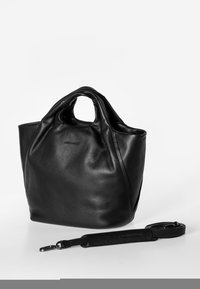 Zwarte leren tote bag met een zachte textuur, voorzien van dubbele handvatten en een verstelbare schouderband, met een afgeronde vorm.