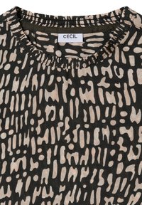 Musta kangastoppi, jossa on teksturoitu, abstrakti beige kuvio. Siinä on kerätty pääntie ja etiketti, jossa lukee "CECIL".