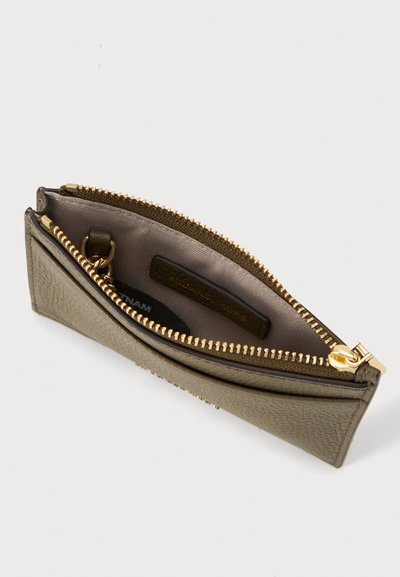 Petit portefeuille en cuir vert olive avec fermeture éclair dorée ouverte, intérieur en tissu et porte-clés visible à l'intérieur.