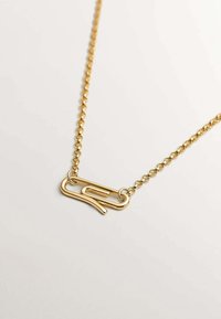Collar en tono dorado con un colgante en forma de clip de papel. La cadena está compuesta por eslabones redondos uniformes, lo que añade textura y brillo.