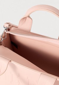 Pink textured leather handbag with a zip closure, featuring dual top handles and a spacious interior. Subtle herringbone pattern visible.