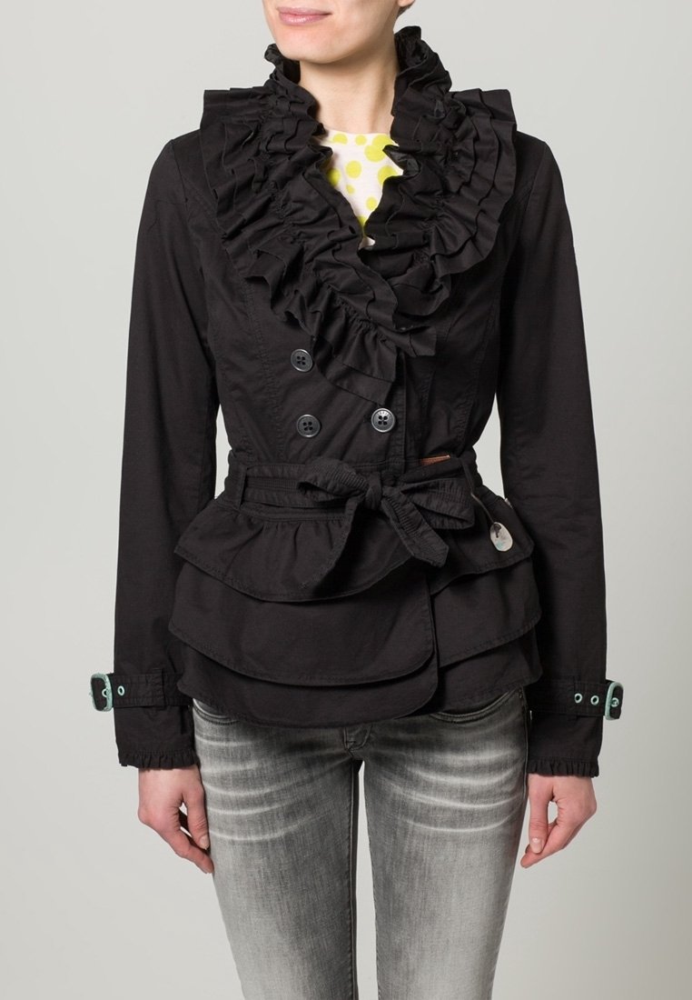 Svart jacka med volanger, dubbelknäppt stängning, peplumdesign och tygskärp. Har knappar och kontrasterande ärmslut.