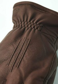 Brun læderhandske med elastisk håndled og tre syede linjer på bagsiden, der viser tekstureret læder og detaljeret syning.