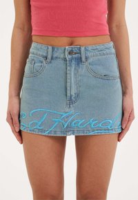 Hellblauer Denim-Minirock mit Fronttaschen, einer Knopfverschluss und blauer, gestickter Schrift "Ed Hardy" entlang dem Saum.