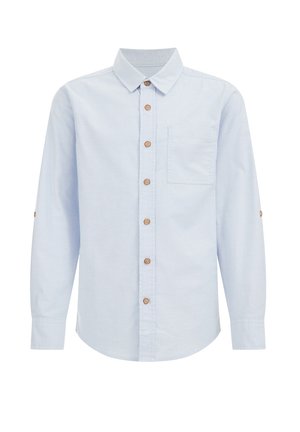 Camisa azul claro de manga larga con botones marrones y un bolsillo en el pecho en el lado izquierdo, mostrada sobre un fondo blanco.