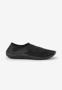 Schwarzer, flexibler Schuh mit einer glatten Obermaterial und einer strukturierten Gummisohle, die kleine hervorstehende Punkte für besseren Halt aufweist. Schlankes Design mit minimalen Akzenten.