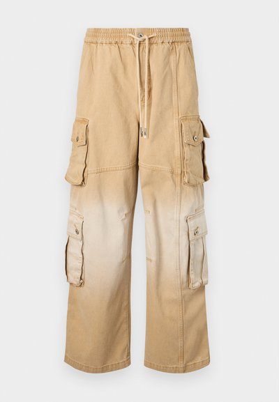 Beige cargo nadrág, rugalmas derékkal és húzózsinórral. Több oldalsó zsebbel rendelkezik. Fokozatos ombre hatás világos bézsből sötét bézsbe.